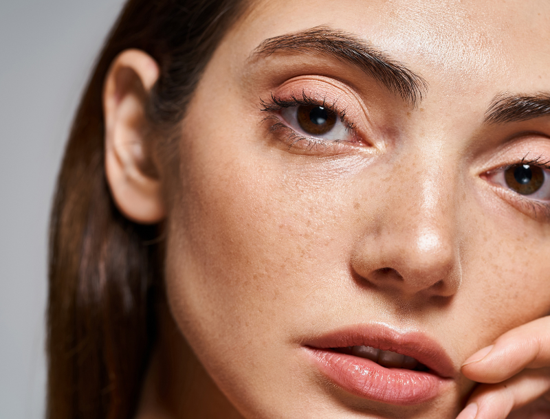 Nahaufnahme eines Frauengesichts mit sichtbaren Poren und leicht geöffneten Lippen